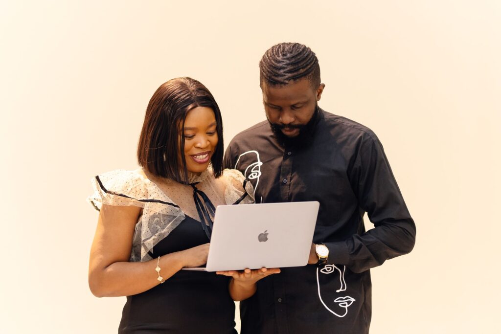 Man and woman working together on a laptop in an African office