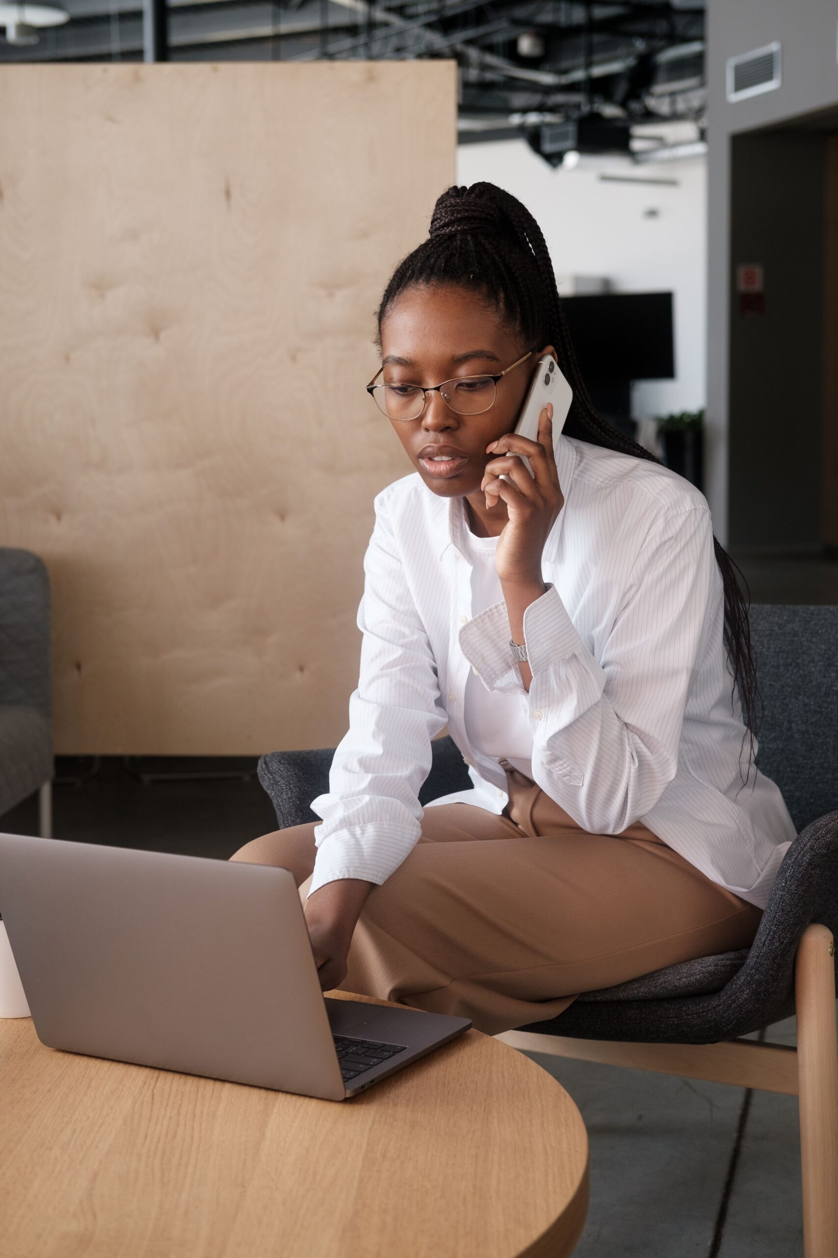 Businesswoman coordinating campaigns on phone and laptop