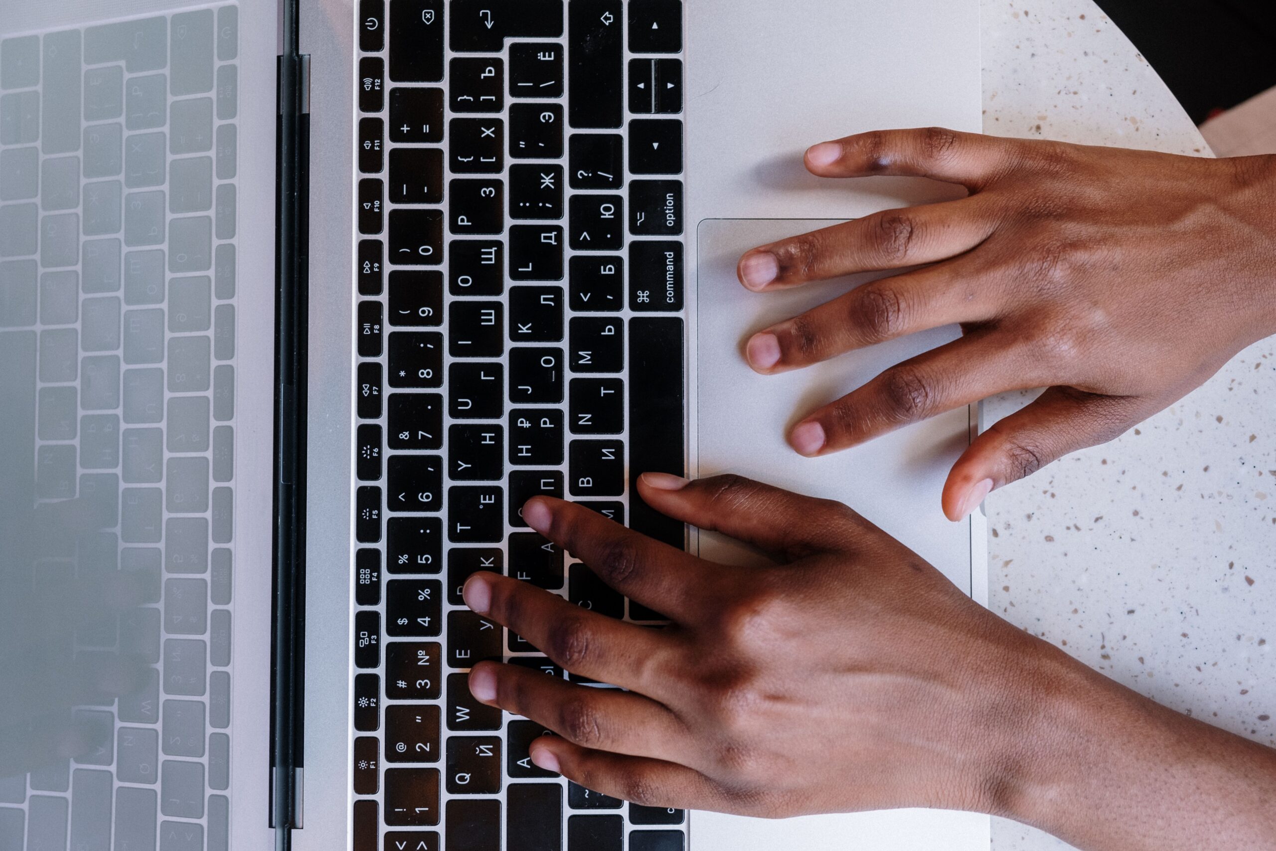 Hands typing SEO content on a laptop keyboard for a business website