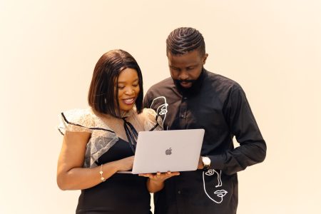 Man and woman working together on a laptop in an African office